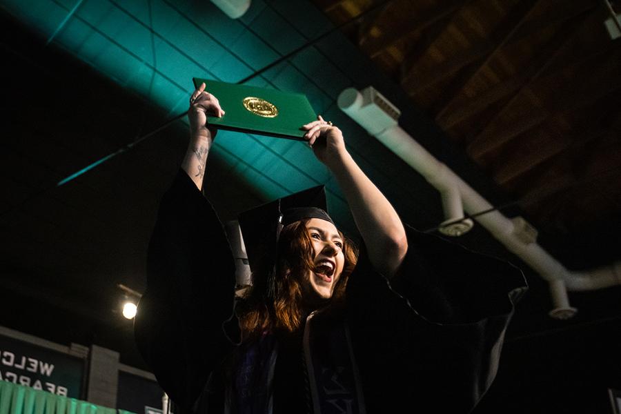 周六，<a href='http://faculty.nkgx.net'>全国网赌正规平台</a>的一名毕业生在毕业典礼上展示她的毕业证书.